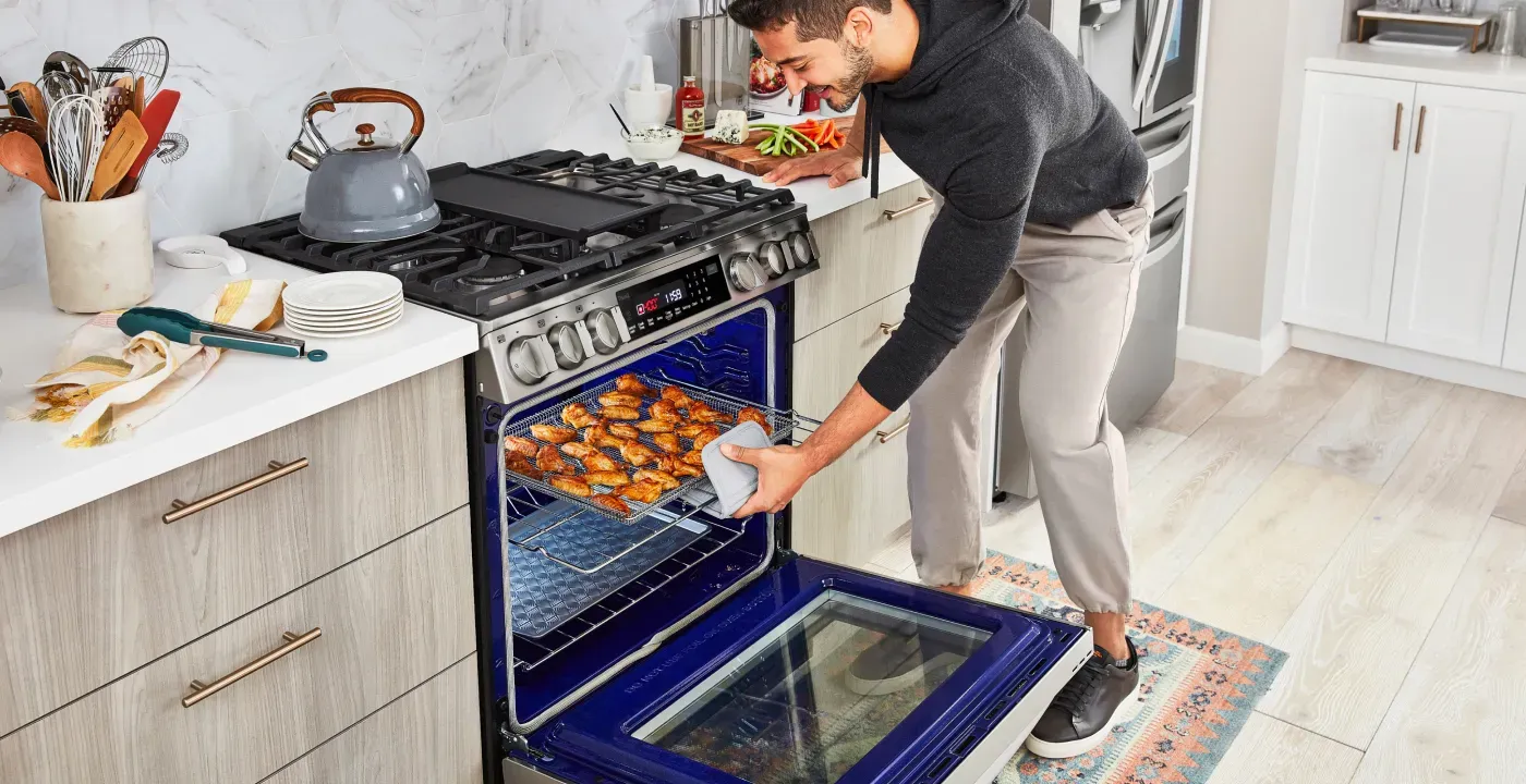 man taking wings out oven